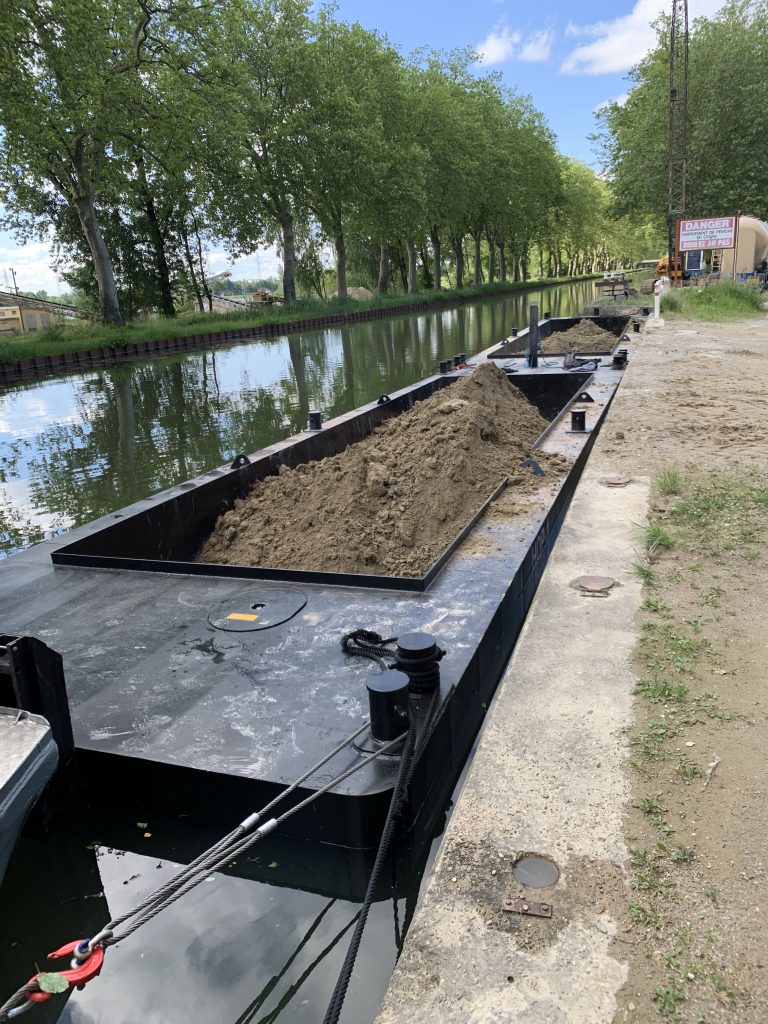 barge de transport fluviale remplie de matériaux en convoi