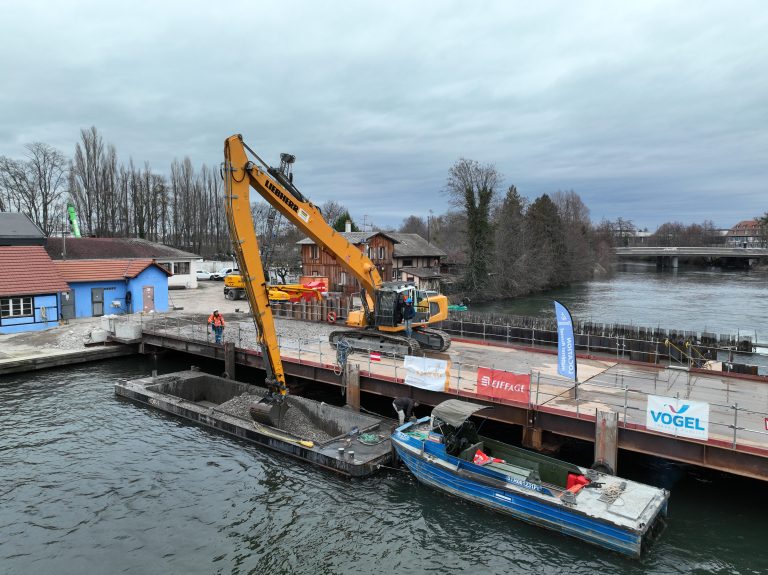 Barges de transport en chargement à quai avec pousseur fluvial à l'arrière